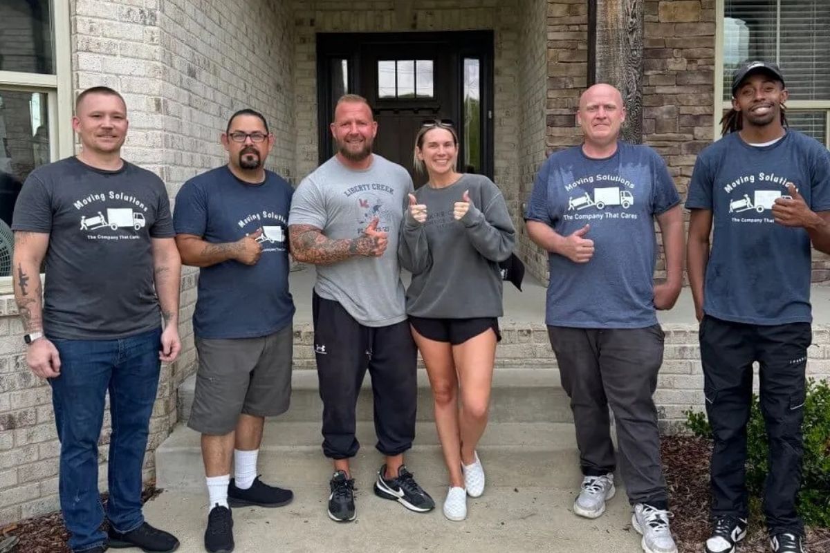 Moving Solutions team in front of house with clients