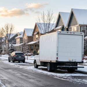 moving truck parked on a quiet suburban street during winter