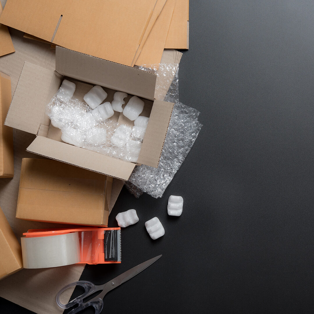 Packing accessories on dark background,Foam cushion,Shockproof plastic wrap,Cardboard boxes with tape,Packing, shipping concept