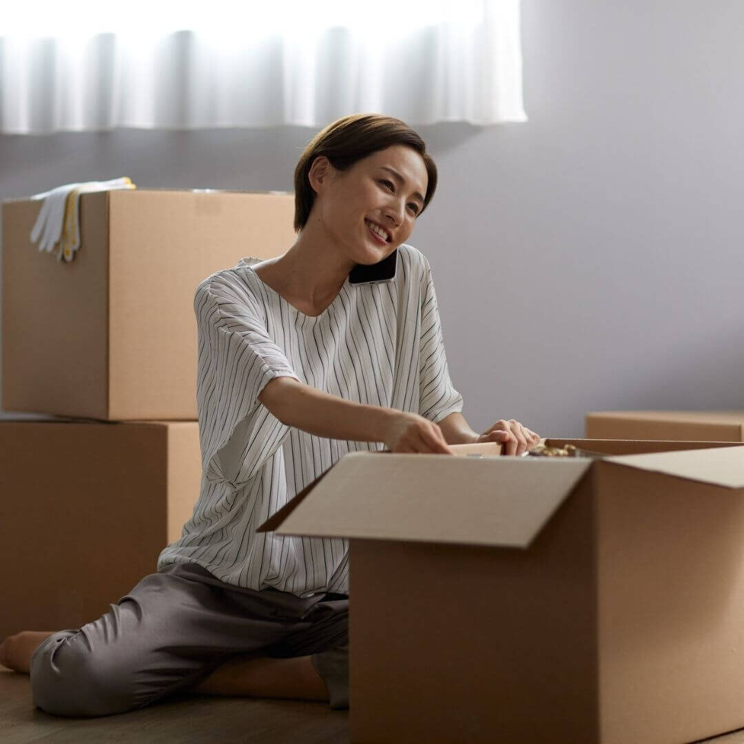 woman on the phone while packing boxes