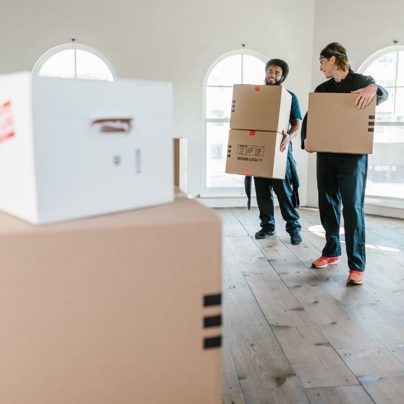 movers bringing packed boxes out of house