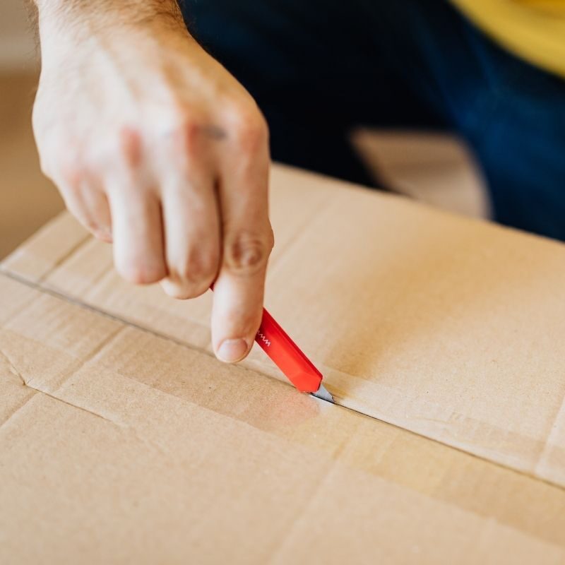 mover using a box cutter to open a box